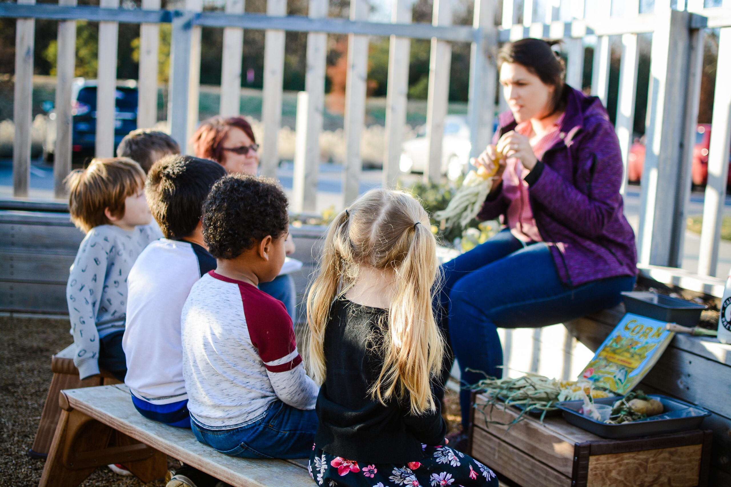 children learning outdoors with teacher
